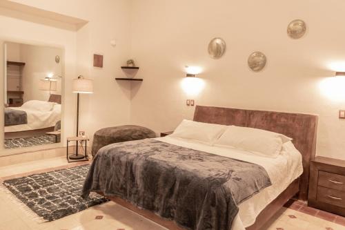 a bedroom with a large bed and a mirror at Kuxtal Hotel Boutique in Mérida