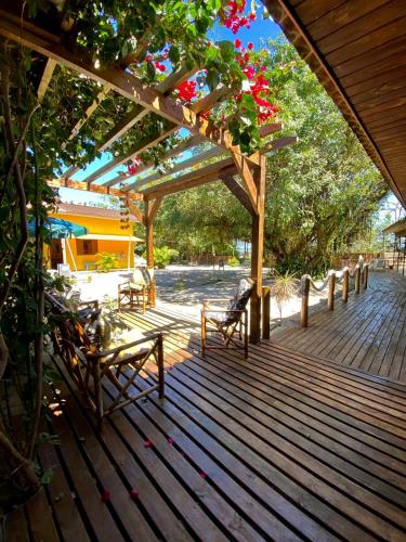 a wooden deck with benches and flowers on it at Pousada & Camping Tubarão in Ilha do Mel