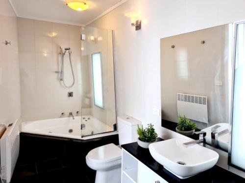 a bathroom with a tub and a sink and a toilet at Red Robin in Mount Hotham