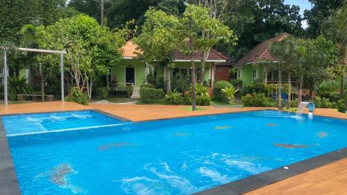 a large blue swimming pool in front of a house at Somrudee Resort in Nakhon Nayok