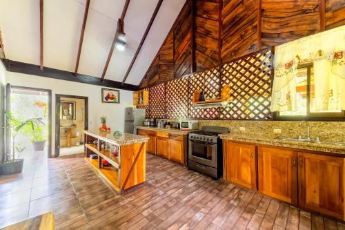 a kitchen with wooden cabinets and wooden flooring at Casa Shaquir H - Coastal Bliss Oasis in Puerto Viejo
