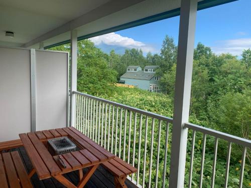 a balcony with a table and a view of a house at Yotei Townhouse - 2 bedrooms with covered BBQ deck in Niseko