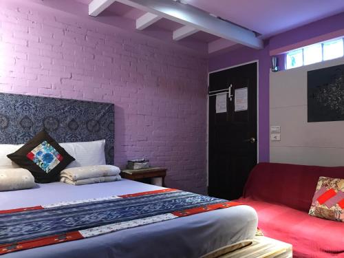 a bedroom with a bed and a red couch at A-HOME in Jiufen