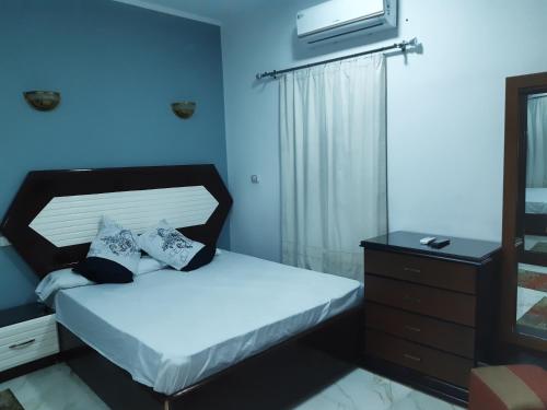 a small bedroom with a bed and a dresser at German Dolphin in Quseir