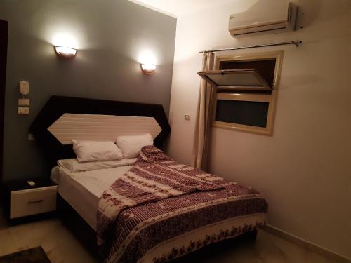 a small bedroom with a bed and a window at German Dolphin in Quseir