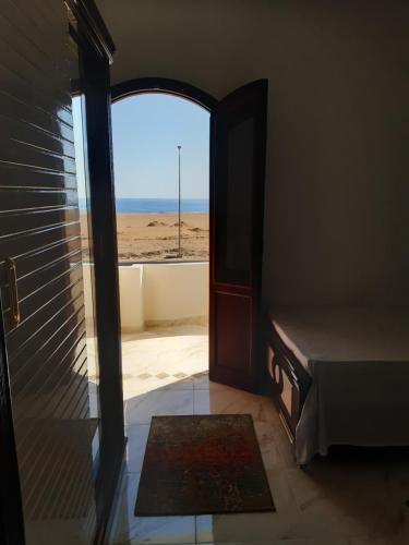 an open door to a room with a view of the beach at German Dolphin in Quseir