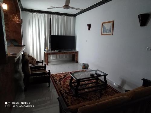 a living room with a tv and a couch and a table at German Dolphin in Quseir