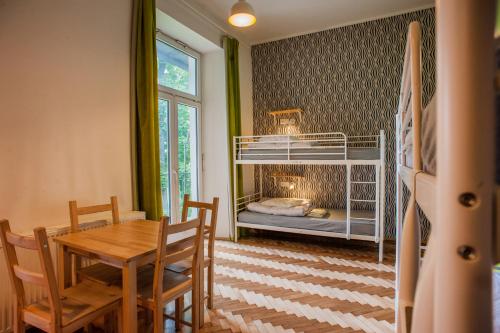 a dining room with a table and a bunk bed at Atlantis Hostel in Kraków