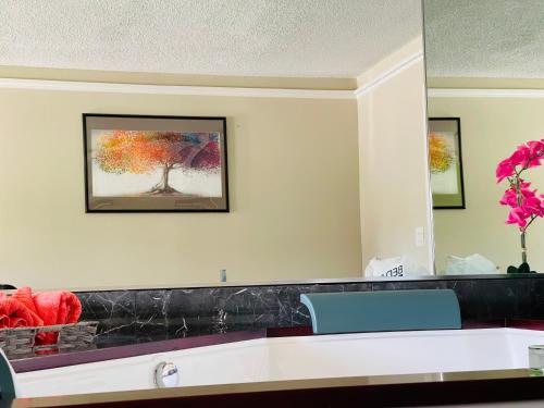 a reception desk with a painting of a tree at Classic Motor Lodge Providence - West Greenwich in West Greenwich