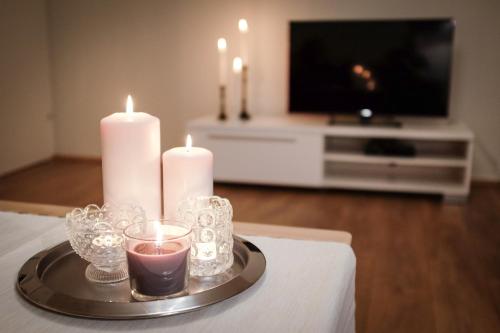 bandeja con velas en una mesa con TV en Thoristun Apartments, en Selfoss