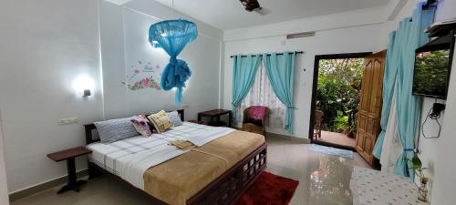 ein Schlafzimmer mit einem großen Bett und einem großen Fenster in der Unterkunft Periyar Inn in Thekkady