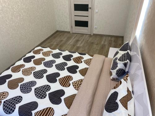 uma cama com um edredão e almofadas preto e branco em Люкс апартаменти в ЖК Театральному.Центр міста em Rivne