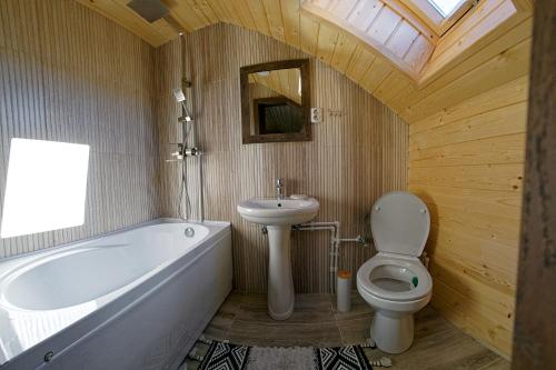 ein Badezimmer mit einer Badewanne, einem WC und einem Waschbecken in der Unterkunft La Roata Timpului in Câmpulung Moldovenesc