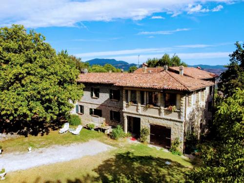 una vista exterior de una casa de piedra con árboles en Angolo di Paradiso B&B, en Grizzana