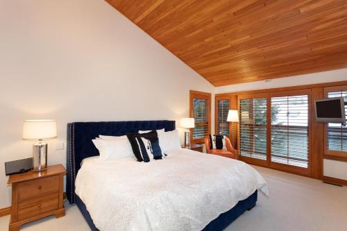 a bedroom with a large bed and a wooden ceiling at Luxury 5 Bedroom Blueberry Chalet in Whistler