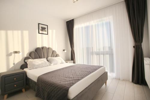 a bedroom with a large bed with a large window at Apartament Prima Nufarul Ralu in Oradea