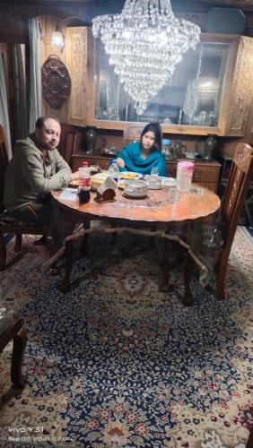 a man and a woman sitting at a table at Houseboats Jackson Heights in Srinagar