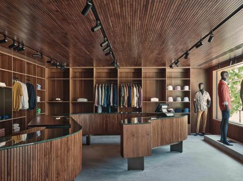 a man standing in a dressing room with wooden walls at Patina Maldives, Fari Islands in North Male Atoll