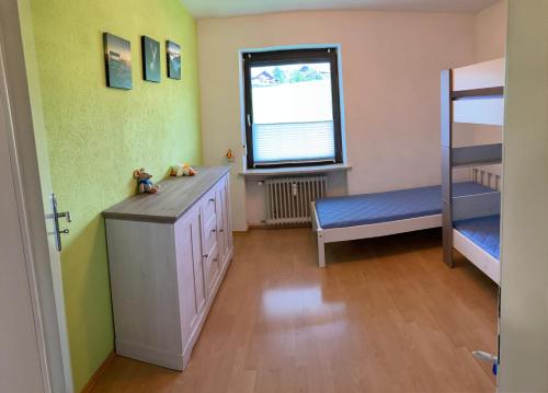 a small room with a bunk bed and a bench at Ferienwohnung Im Moos in Oberstaufen