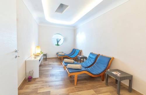 a waiting room with blue chairs and a table at Hotel Grazia alla Scannella in Ischia