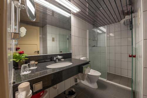 a bathroom with a sink and a toilet and a mirror at Creta Solaris Holiday Apartments in Stalís