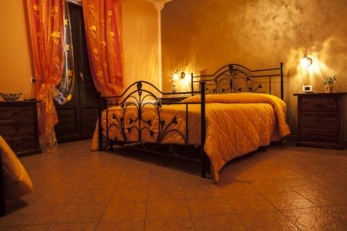 a bedroom with a bed with an orange blanket on it at Agriturismo La Gemma del Parco in Mormanno