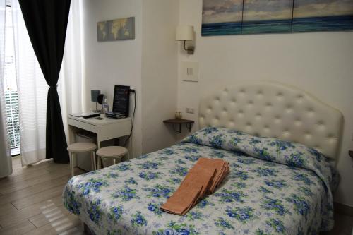 een slaapkamer met een bed met een deken en een bureau bij Domus San Biagio 14 in Napels