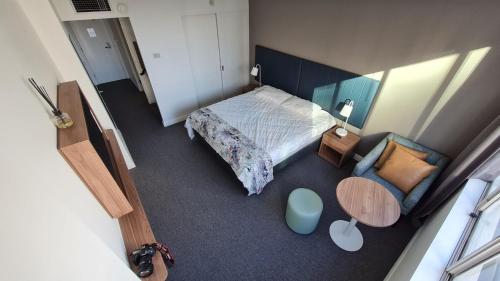 a small bedroom with a bed and a chair at Chatswood Hotel Apartment in Sydney