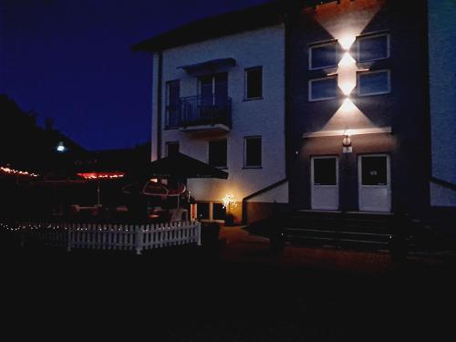 a building with a light on the side of it at night at Siedlisko na Zaciszu Gościniec in Kąty Rybackie