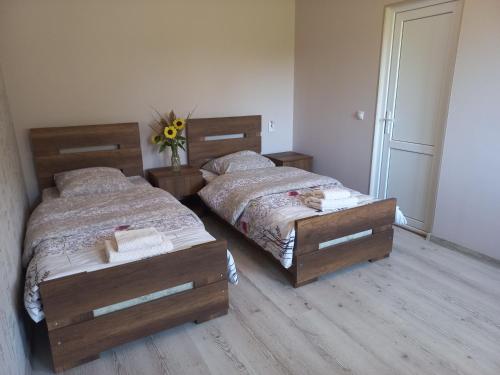 a bedroom with two beds and a vase of flowers at Bee House in Kilda