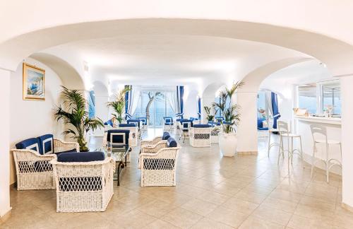 a room with chairs and tables and blue chairs at Hotel Grazia alla Scannella in Ischia