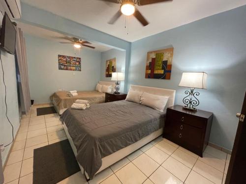 a bedroom with two beds and a ceiling fan at 3BR sleeps up to 12, Remodeled and Very Cozy in Catano