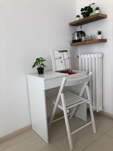 a white desk with a chair next to a radiator at Marco Polo GreenRoom in Milan