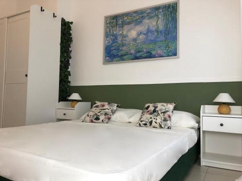 ミラノにあるMarco Polo GreenRoomのベッドが2つあり、壁に絵が飾られた寝室