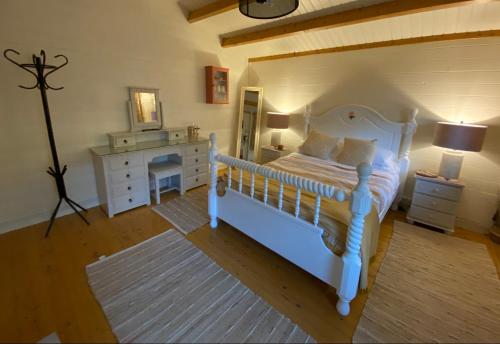 a bedroom with a white bed and a dresser at Beaufort House Accomodation in New Ross