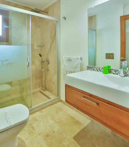 a bathroom with a shower and a sink and a toilet at Çınarlar Apart Hotel KAŞ in Kas