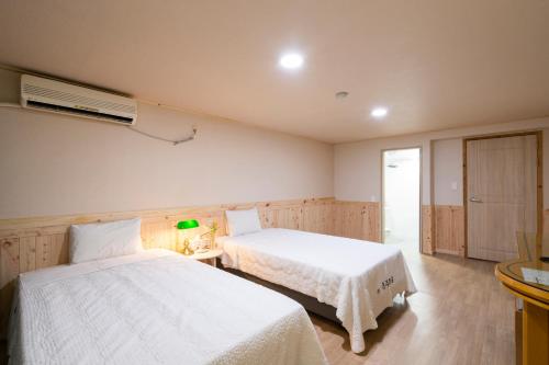 a bedroom with two beds and a air conditioner at New Jeju Hotel in Jeju