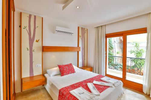 a bedroom with a bed and a window at Çınarlar Apart Hotel KAŞ in Kas