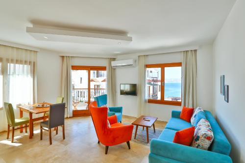 een woonkamer met een blauwe bank en stoelen en een tafel bij Çınarlar Apart Hotel KAŞ in Kas