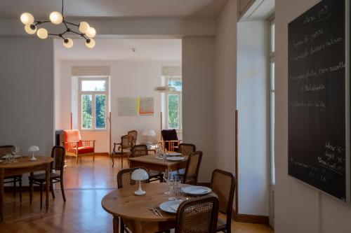 a dining room with tables and chairs and a chalkboard at Villa Pineta in Fusio