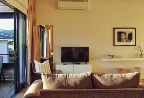 a living room with a couch and a television at 210 Gallery Luxury Studio Apartment in Knysna