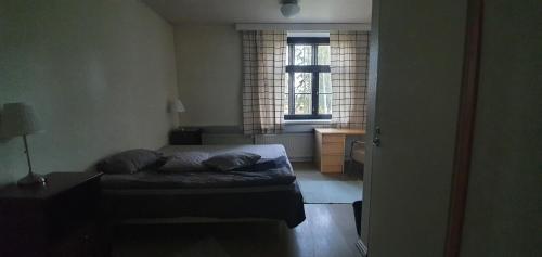 een kleine slaapkamer met een bed en een raam bij Ainola in Hämeenlinna