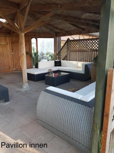 a patio with couches and tables on a porch at Ferien Mecklenburgische Seenplatte, Urlaub auf dem Gutshof Bossow in Bossow