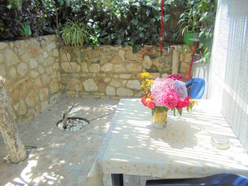 un jarrón lleno de flores sentado en una mesa en Zace Studios, en Ksamil