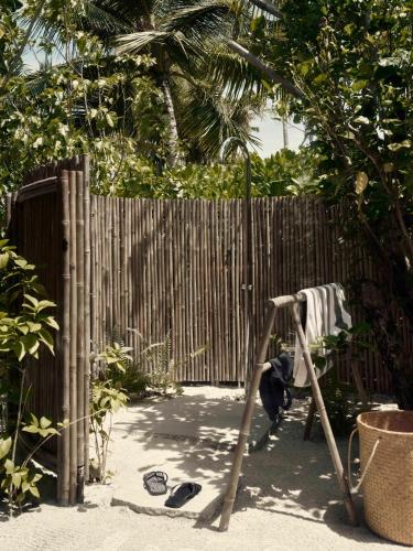 a child playing on a swing set in front of a fence at Patina Maldives, Fari Islands in North Male Atoll