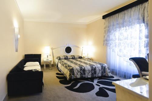 ボローニャにあるヅァンホテル トレ ヴェッチのベッドルーム1室(ベッド1台、椅子、ソファ付)