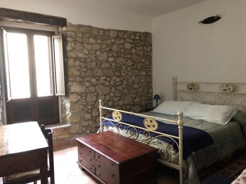 ein Schlafzimmer mit einem Bett und einer Steinmauer in der Unterkunft Il Minotauro B&B a 5 minuti da Popoli in Vittorito