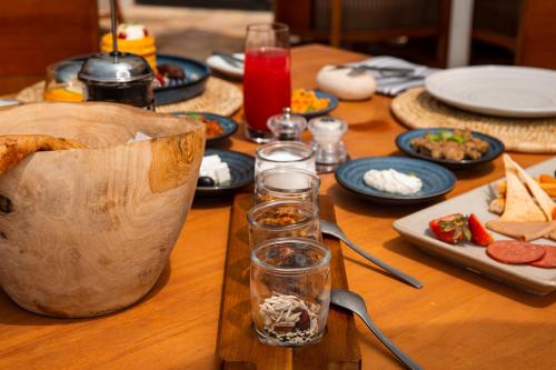 a wooden table with plates of food and glasses on it at Alila Hinu Bay Salalah Mirbat in Salalah