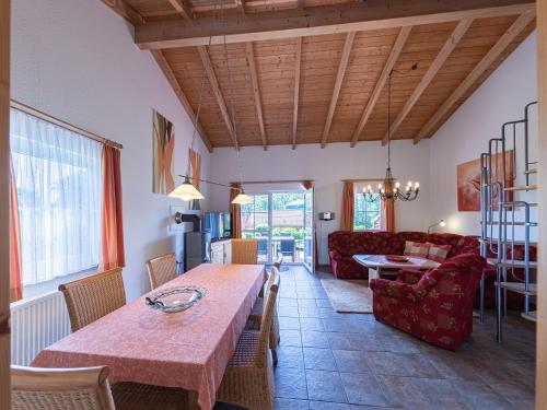sala de estar con mesa y sofá rojo en Haus Himmelblau am Jabeler See en Jabel