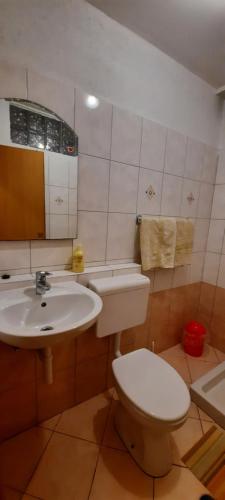 ツレスにあるApartment Lucijaの白いトイレと洗面台のあるバスルーム